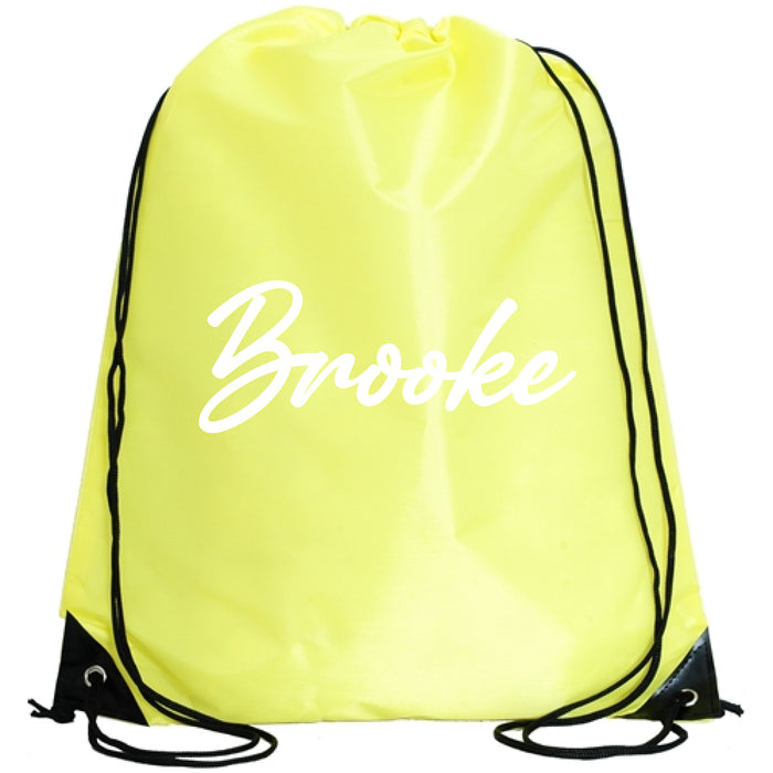 A yellow drawstring bag with the name "Brooke" printed on it in white cursive font.