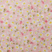 a pattern of white and yellow daisies with green leaves scattered throughout a pink background.