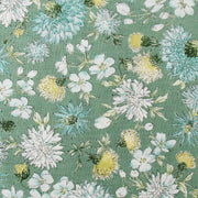 a close-up view of a fabric with a floral pattern. The fabric has a variety of flowers in different colors, including white, yellow, and green, arranged in a visually appealing manner. The flowers are depicted in various stages of bloom, creating a dynamic and lively appearance. The fabric appears to be made of a soft, textured material, suitable for use in clothing or other textile applications.