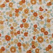 The image is a close-up of a fabric with a floral pattern of orange and yellow flowers and green leaves.