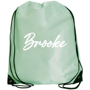 A mint green drawstring backpack with the name "Brooke" printed on it in white cursive text.