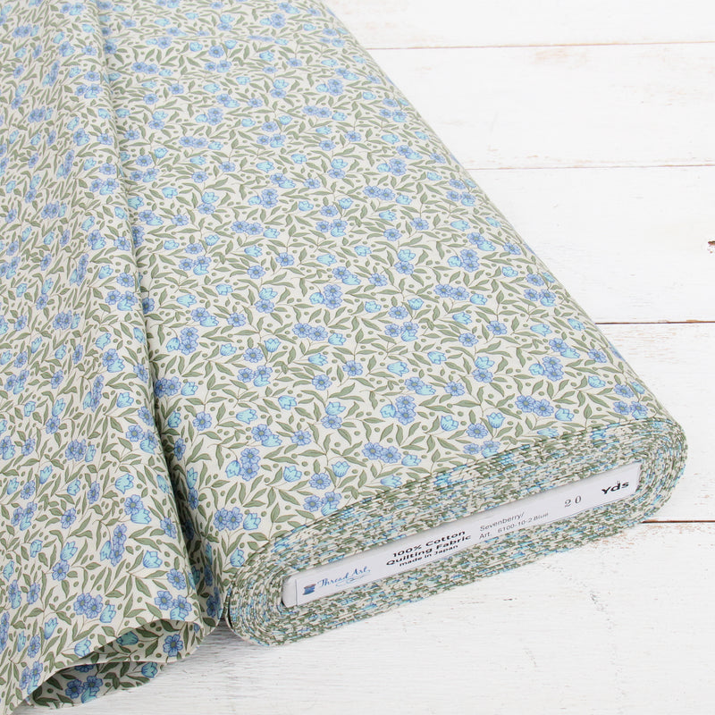 a roll of fabric with a floral pattern in shades of green and blue.
