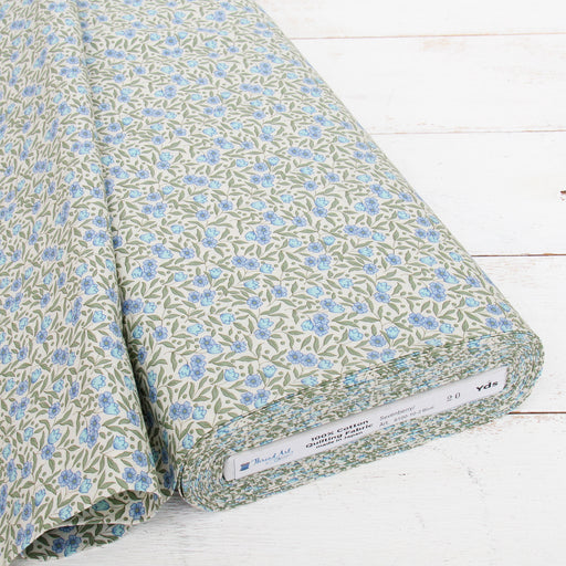 a roll of fabric with a floral pattern in shades of green and blue.