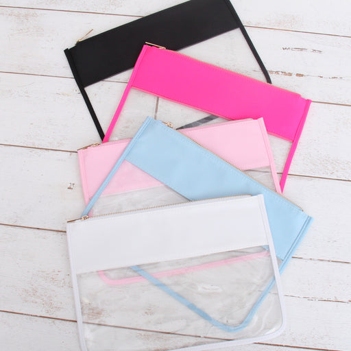 Clear zipper pouch bags in black, hot pink, light pink, light blue, and white on a white wood table