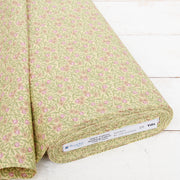 A roll of fabric with a floral pattern in shades of green and pink.