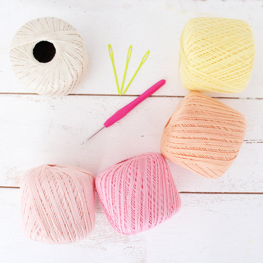 Crochet Hook And Balls Of Cotton Yarn Pastel Colors On A White